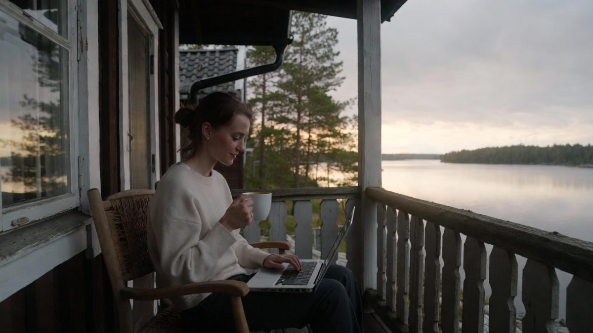 Yrittäjä työskentelee kannettavalla järven rannalla